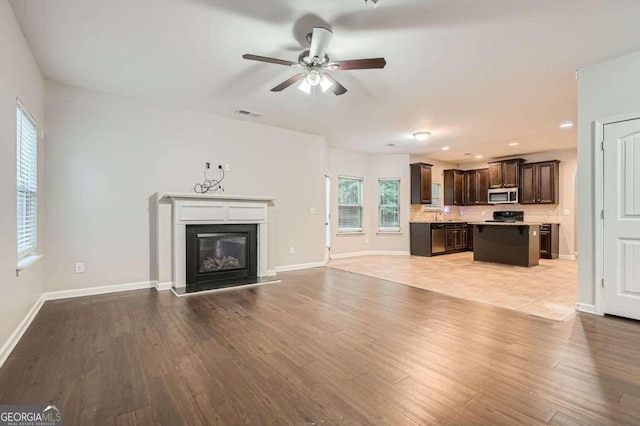 unfurnished living room featuring ceiling fan and light hardwood / wood-style flooring