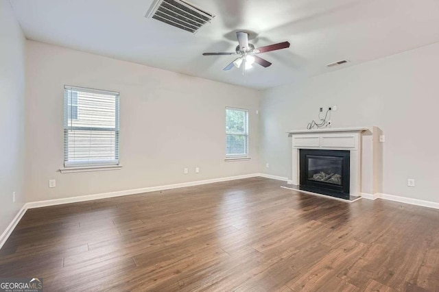 unfurnished living room with ceiling fan and dark hardwood / wood-style flooring