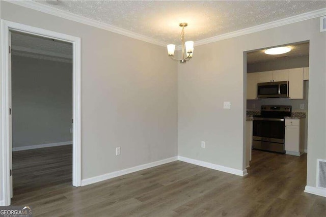 unfurnished dining area featuring ornamental molding, hardwood / wood-style floors, a chandelier, and a textured ceiling