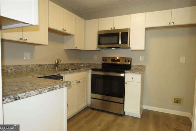 kitchen with light hardwood / wood-style floors, white cabinetry, sink, and stainless steel appliances