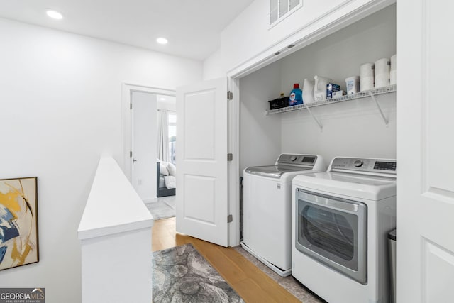 laundry room featuring light wood-type flooring and washing machine and clothes dryer