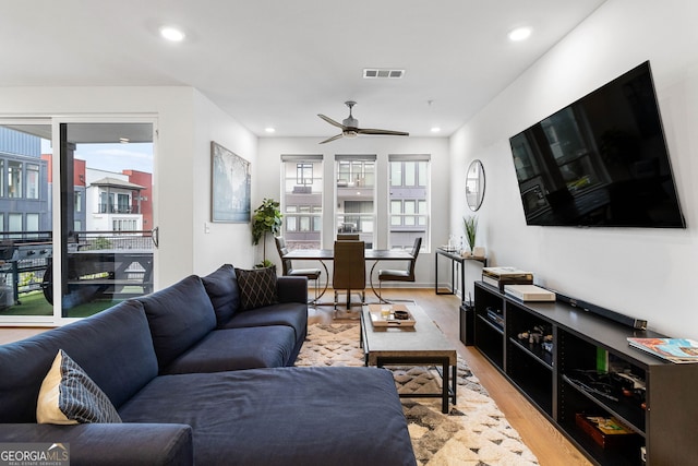 living room with light wood-type flooring and ceiling fan