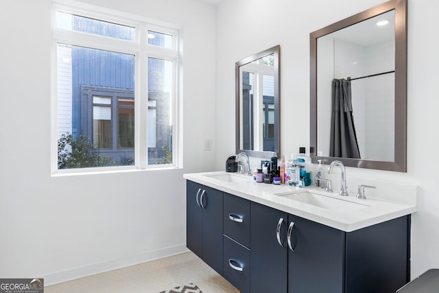 bathroom with a shower with curtain, vanity, and a healthy amount of sunlight