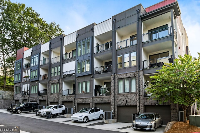 view of building exterior with a garage and central AC