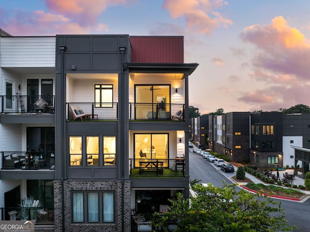 back house at dusk featuring a balcony