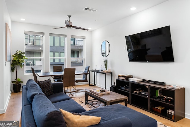 living room featuring ceiling fan and light hardwood / wood-style flooring