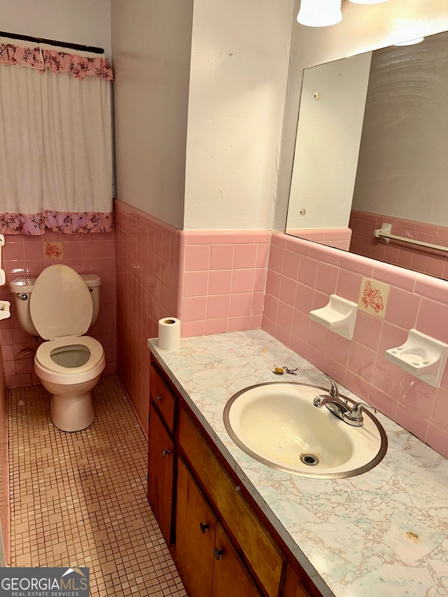 bathroom with vanity, tile walls, toilet, and tile patterned floors