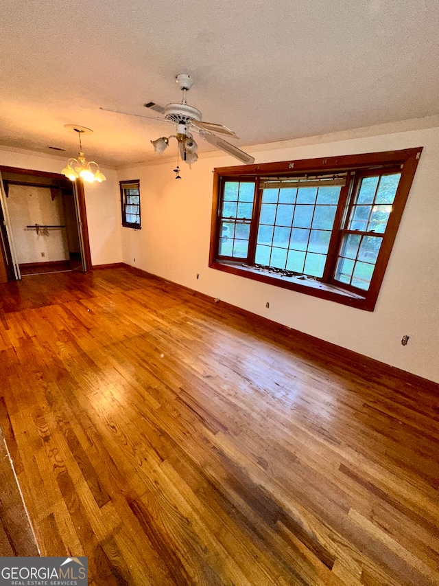 unfurnished living room featuring a wealth of natural light, hardwood / wood-style floors, and a textured ceiling