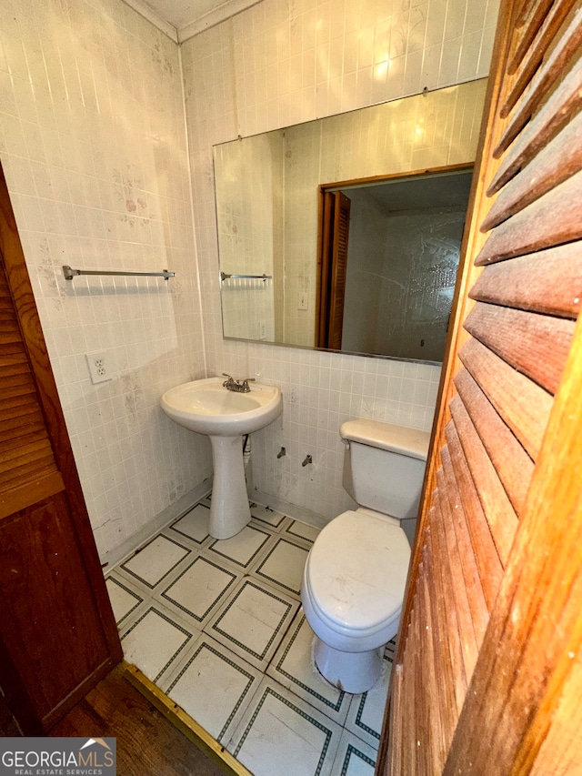 bathroom featuring tile walls and toilet