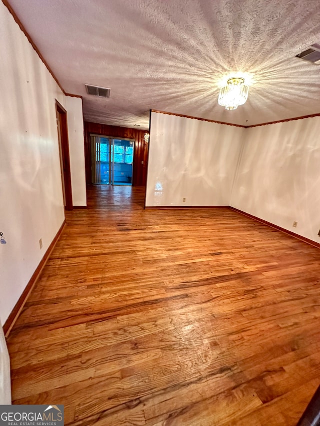 empty room with hardwood / wood-style floors and a textured ceiling