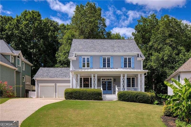 colonial inspired home featuring an outbuilding, a porch, a garage, and a front lawn