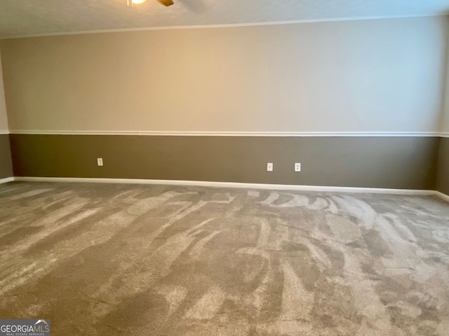 carpeted spare room featuring crown molding and ceiling fan