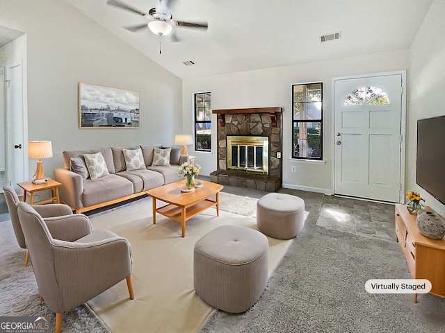 living room with a fireplace, ceiling fan, and vaulted ceiling