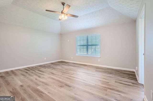 empty room featuring wood-type flooring, a textured ceiling, ceiling fan, and lofted ceiling