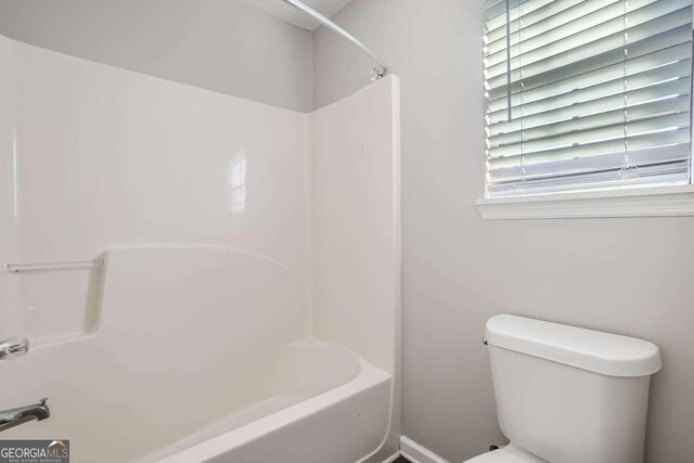 bathroom featuring shower / bathtub combination and toilet