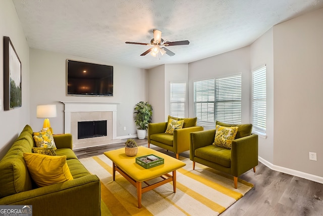 living room featuring ceiling fan, hardwood / wood-style floors, and a textured ceiling