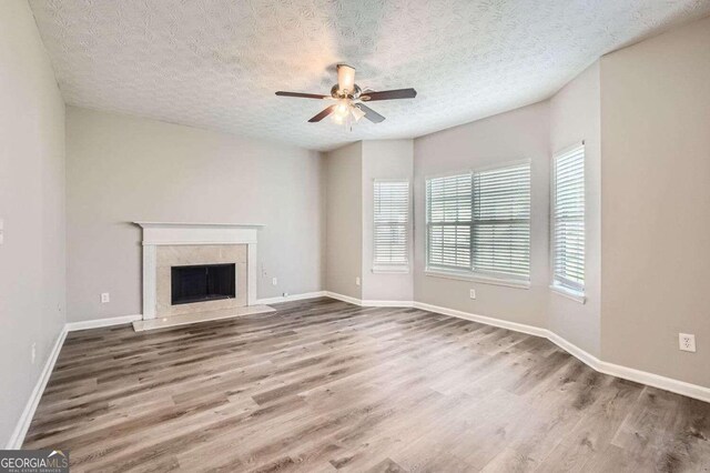 unfurnished living room featuring hardwood / wood-style floors, a textured ceiling, and ceiling fan