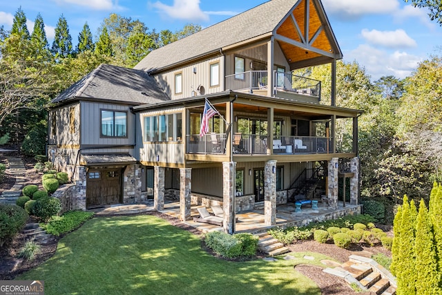 back of house featuring a lawn, a patio, and a balcony