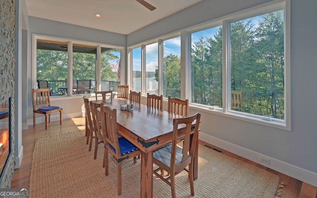 sunroom / solarium with a water view, a healthy amount of sunlight, and ceiling fan