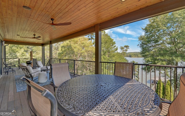 wooden terrace featuring ceiling fan and a water view