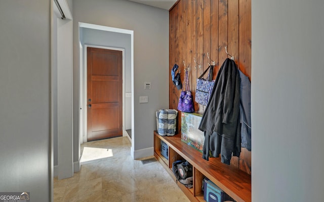 mudroom featuring wood walls