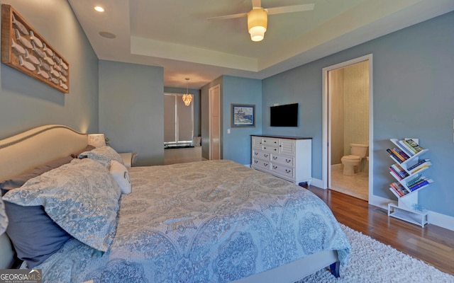 bedroom featuring ceiling fan, dark hardwood / wood-style floors, and connected bathroom