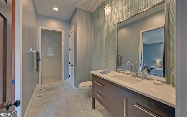 bathroom featuring vanity, toilet, and tiled shower