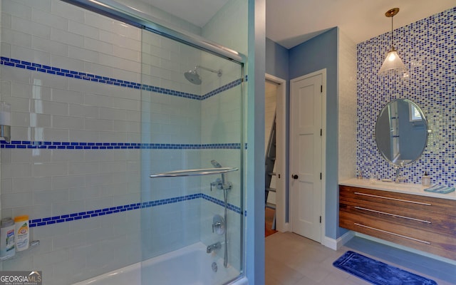 bathroom featuring vanity, tile patterned flooring, and enclosed tub / shower combo