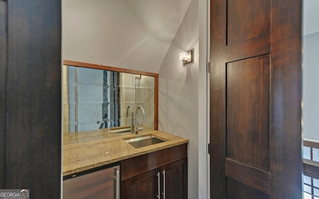 bathroom with wine cooler, vanity, and vaulted ceiling