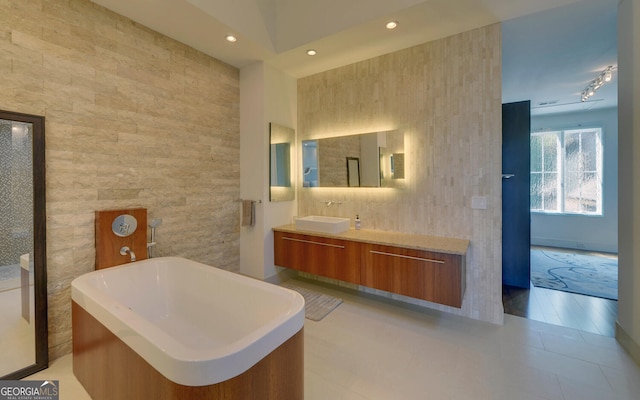 bathroom with tile walls, vanity, and tile patterned floors