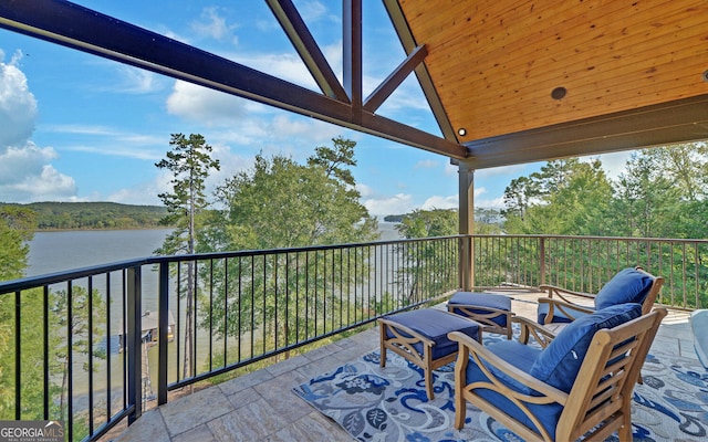 exterior space with a water view, an outdoor living space, and a balcony