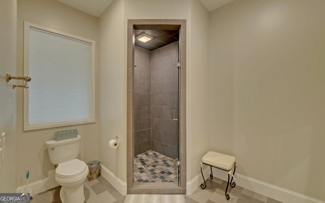 bathroom featuring toilet, an enclosed shower, and tile patterned floors