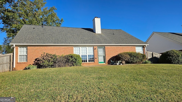 rear view of property with a lawn