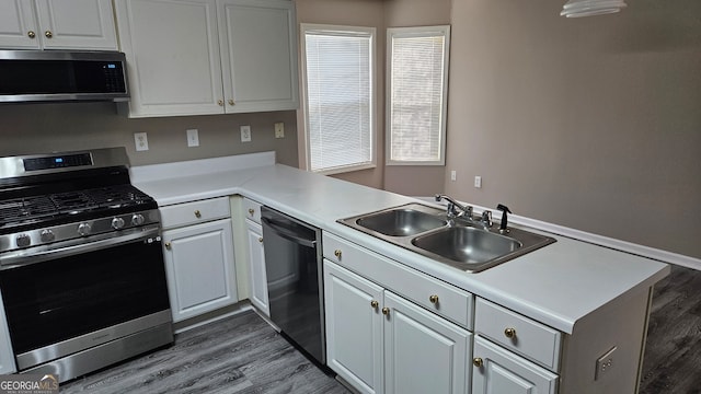 kitchen with kitchen peninsula, white cabinets, and appliances with stainless steel finishes