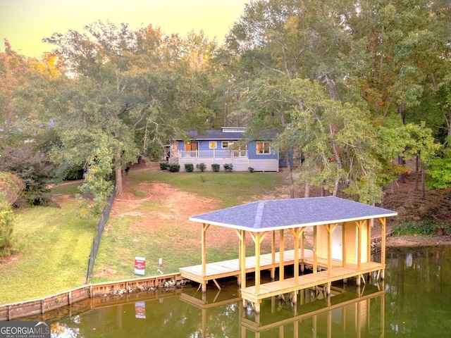 view of dock featuring a lawn and a water view