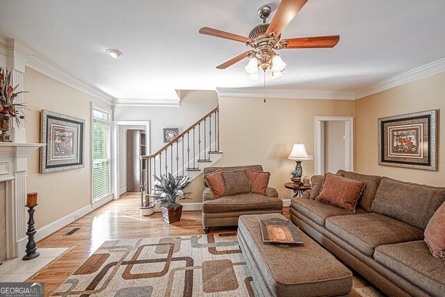 living room featuring ornamental molding, light wood-type flooring, and ceiling fan