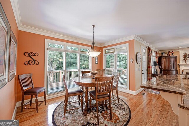 dining room with ornamental molding and light wood-type flooring