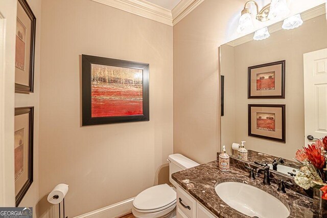 bathroom featuring ornamental molding, vanity, and toilet