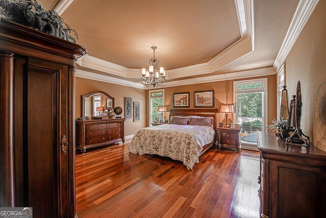 bedroom featuring a tray ceiling, dark hardwood / wood-style flooring, and multiple windows