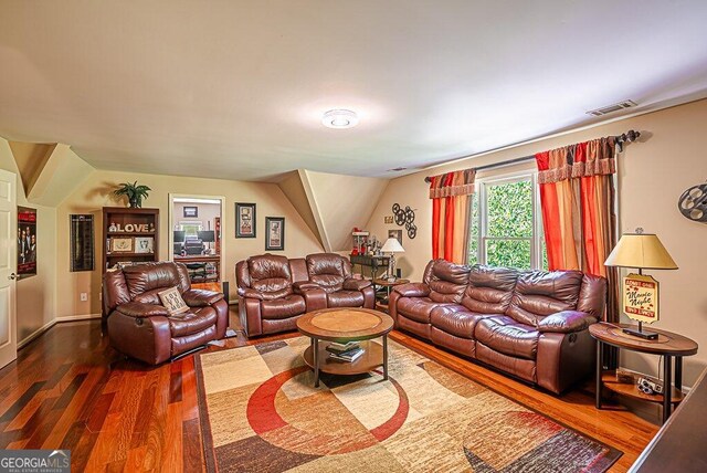 living room featuring lofted ceiling and dark hardwood / wood-style flooring