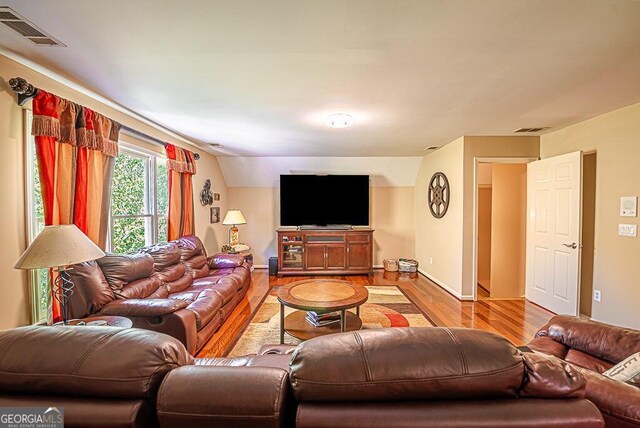 living room featuring vaulted ceiling and light hardwood / wood-style floors