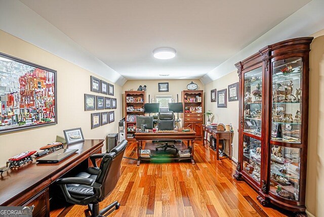 home office with vaulted ceiling and light wood-type flooring