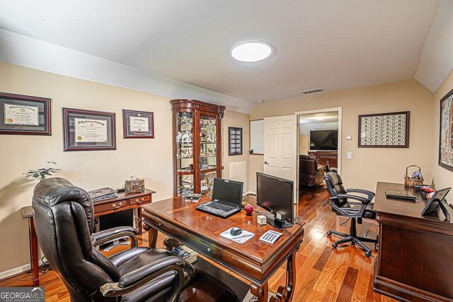 office area featuring wood-type flooring and vaulted ceiling