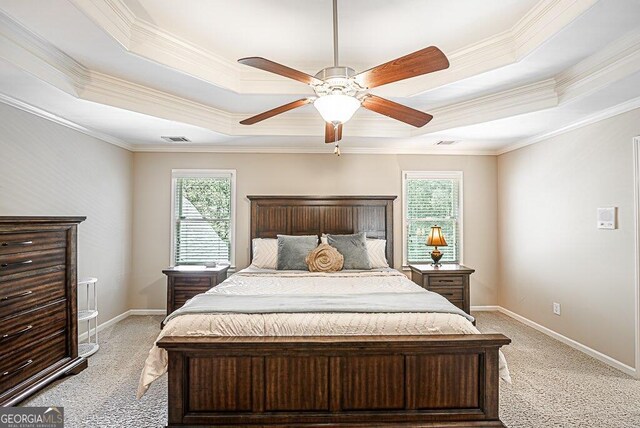 carpeted bedroom with ceiling fan, a raised ceiling, and crown molding