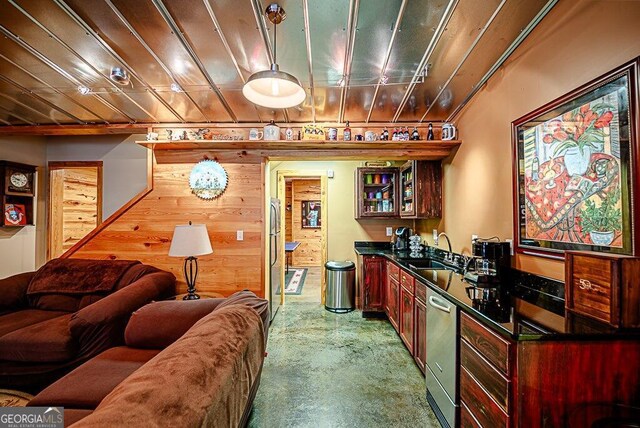 interior space with concrete flooring, wooden walls, and sink