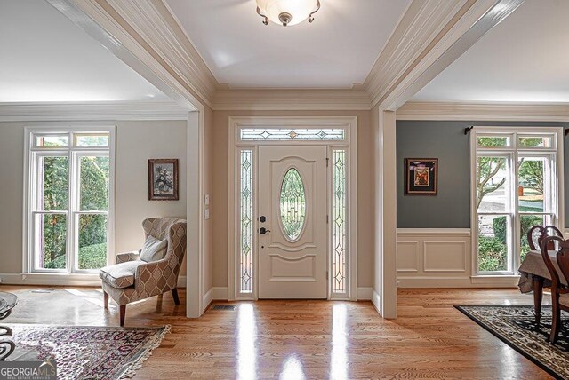 entryway featuring ornamental molding and light wood-type flooring