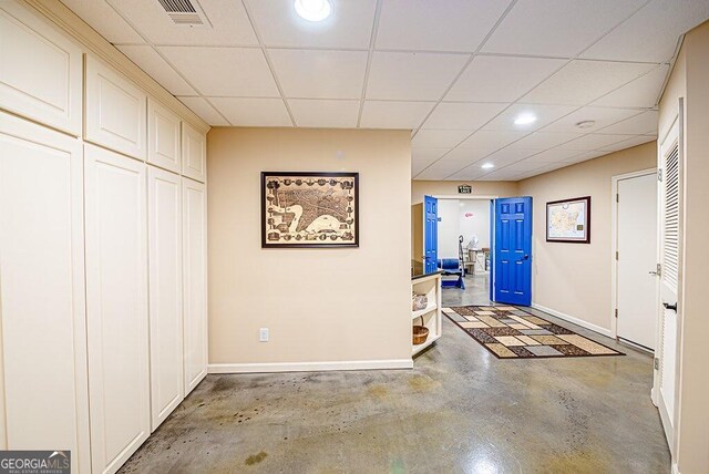 entrance foyer featuring a drop ceiling and concrete floors