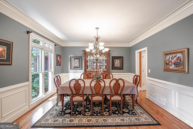 dining area featuring light hardwood / wood-style floors, ornamental molding, and a healthy amount of sunlight