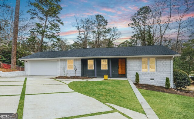 ranch-style home with a lawn and a garage