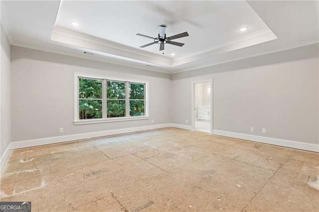 unfurnished room with a raised ceiling, crown molding, and ceiling fan